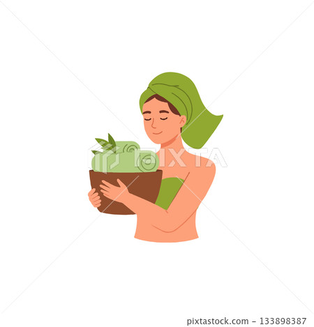 Serene woman with towel turban holding spa basket full of fresh rolled towels and green leaves Serene woman with towel turban holding spa basket full of fresh rolled towels and green leaves 133898387
