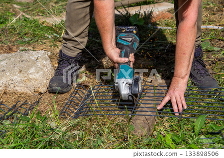 Grinding a fence with a grinding machine Grinding a fence with a grinding machine 133898506