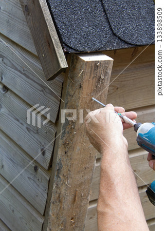 Handyman installing a wooden rabbit house 133898509