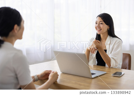 Women chatting at a table Women chatting at a table 133898942
