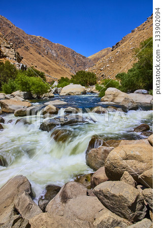 Kern River Rapids with Rocky Waterfall and Green Trees in Sunlit Mountain Landscape 133902094