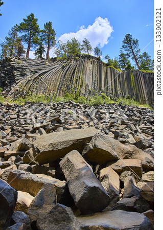 Basalt Columns and Broken Rocks at Devils Postpile in California Under Blue Sky 133902121
