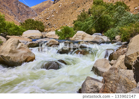 Kern River Rapids Flowing Over Rocks with Green Trees and Arid Hills Kern River Rapids Flowing Over Rocks with Green Trees and Arid Hills 133902147