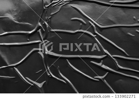 black crumpled and creased plastic poster texture background 133902271