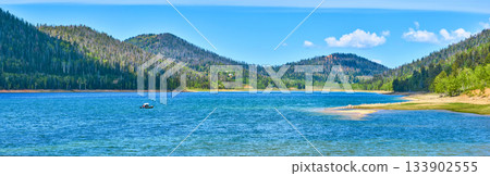 Panorama Lake Boat and Forested Hills Under Blue Sky Panorama Lake Boat and Forested Hills Under Blue Sky 133902555