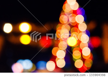outdoor scene defocused christmas tree. festive abstract background of street for new year with bokeh effect. colorful backdrop with shimmering garlands for winter holidays 133904398