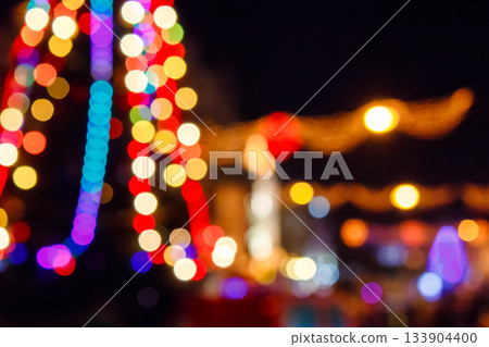 outdoor scene defocused christmas tree. festive abstract background of street for new year with bokeh effect. colorful backdrop with shimmering garlands for winter holidays outdoor scene defocused christmas tree. festive abstract background of street for new year with bokeh effect. colorful backdrop with shimmering garlands for winter holidays 133904400