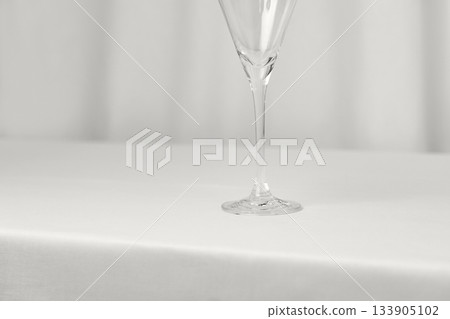 Empty wine glass on cotton background. Minimalist luxury color of 2026 year cloud white 133905102