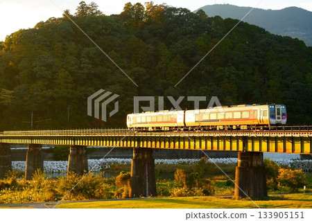 夕陽西下，N2000系列宇和海特快列車沐浴在餘暉中。 133905151