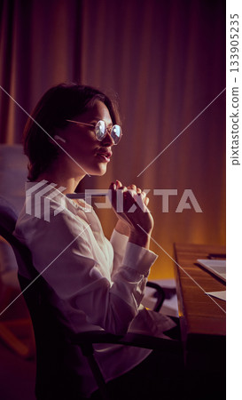 Woman thinking at desk while holding pen during reflective work moment Woman thinking at desk while holding pen during reflective work moment 133905235