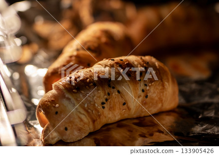 Handcrafted buttery croissant with golden flaky layers and inviting bakery atmosphere Handcrafted buttery croissant with golden flaky layers and inviting bakery atmosphere 133905426