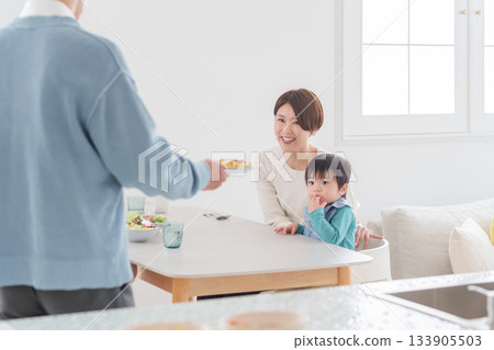 一位父親正在為家人盛飯。 133905503