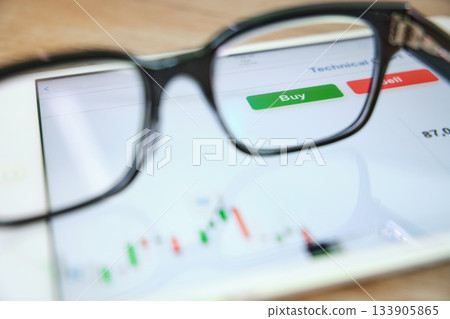 Eyeglasses on tablet showing stock market trading chart Eyeglasses on tablet showing stock market trading chart 133905865