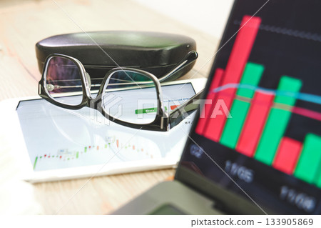 Investment strategy with glasses on tablet showing stock market chart 133905869