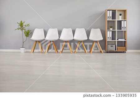 Minimalistic Row of Empty White Chairs at Office 133905935