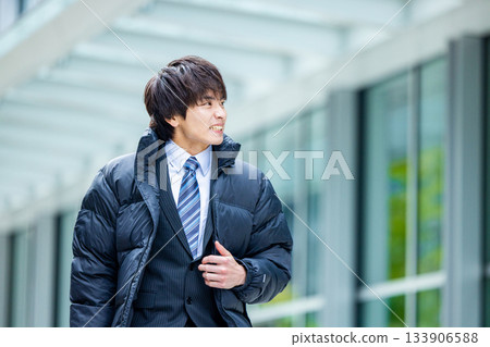Smiling businessman wearing a down jacket 133906588