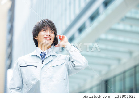 一名身穿工作服的男子正在用智慧型手機通話。 133906625