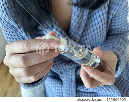 Woman holding a glass jar of facial serum in her hands, skincare beauty product presentation for daily routine, moisturizing treatment and cosmetic self care at home 133906805