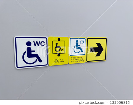 Set of accessible area signs on wall. Wheelchair user sign with arrow sign pointing to accessible elevator and restroom for people with mobility issues Set of accessible area signs on wall. Wheelchair user sign with arrow sign pointing to accessible elevator and restroom for people with mobility issues 133906815