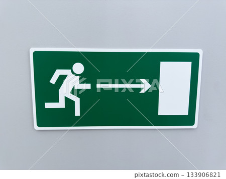 White man on green background runs toward exit. Safety sign on wall is intended to save lives and assist with evacuation. Concept of accidents and incidents, leaving from building 133906821