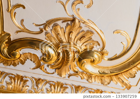 Luxurious gold-leaf ceiling ornament featuring gilded swirling acanthus scrolls 133907259