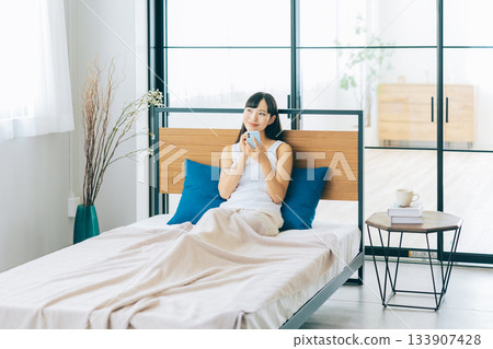 少婦在床上的看智能手機 133907428