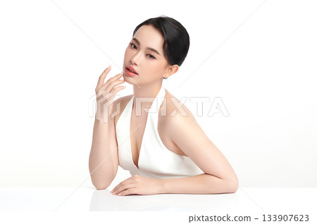 A beautiful young Asian woman with clean, fresh skin against a white background. Skincare, facial treatment, cosmetology, beauty, and spa. An elegant portrait of an Asian woman. 133907623
