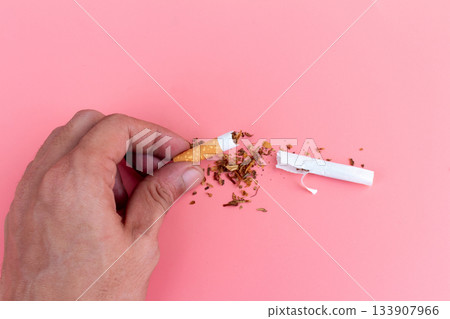 cigarette butts torn on pink background hand cigarette butts torn on pink background hand 133907966