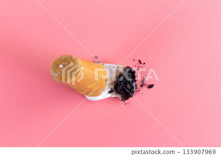 cigarette butts on pink background cigarette butts on pink background 133907969