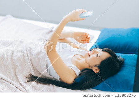 少婦在床上的看智能手機 133908270