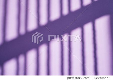 Purple shadow bars cast across light background creating an abstract pattern 133908332