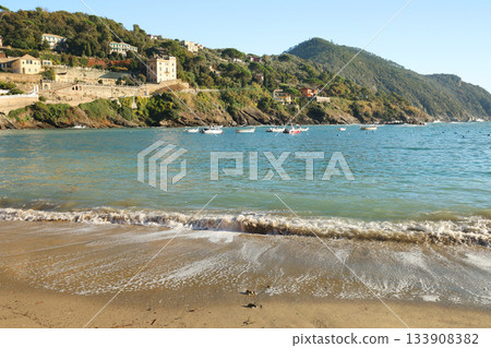 Traditional buildings and houses in seaside bay of Silence in autumn, Sestri Levante. Ligurian nature and architecture. Blue sky, sandy beach, clouds, and backdrop for design. 133908382