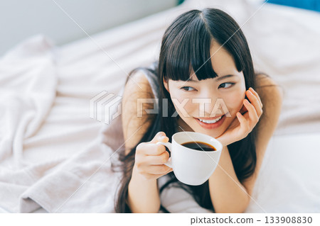 Woman drinking coffee in bed 133908830