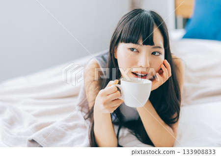 Woman drinking coffee in bed 133908833
