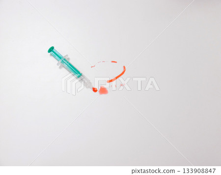 Green Syringe Positioned Near Orange Cap And Red Residue On White Workbench, Clinical Preparation Vibe 133908847
