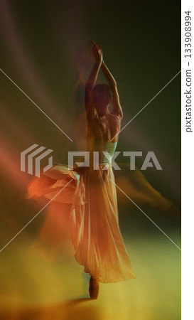 Full-body dancer silhouette in warm flowing motion with elegant skirt movement 133908994