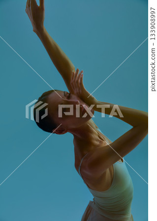 Modern dancer portrait with extended arms in soft turquoise artistic atmosphere Modern dancer portrait with extended arms in soft turquoise artistic atmosphere 133908997