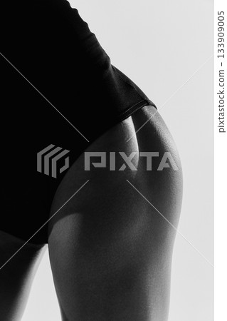 Close-up of ballerina hip in strong studio lighting. 133909005