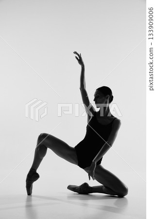 Dramatic silhouette of ballerina in expressive floor pose. Dramatic silhouette of ballerina in expressive floor pose. 133909006