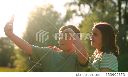 Boy girl taking photo park sunset, children selfie teenagers friends phone, happy schoolchildren selfie smartphone, joyful summer day and a sweet park selfie, golden hour kids taking a fun outdoor Boy girl taking photo park sunset, children selfie teenagers friends phone, happy schoolchildren selfie smartphone, joyful summer day and a sweet park selfie, golden hour kids taking a fun outdoor 133909853