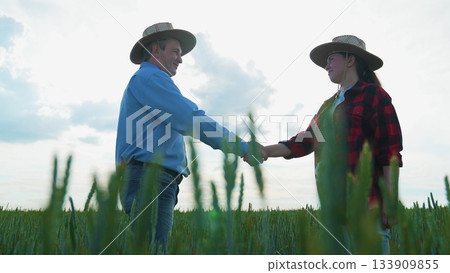 Professional agreement at farm, Farmers meeting at sunrise, Business concluded in nature, Partnership handshake in rural area, Agricultural work friendship, Wheat field cooperation, Rural handshake 133909855