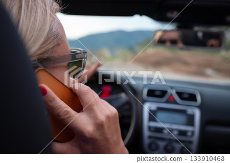 Young woman driving convertible along scenic ocean coast and mountain road at sunset, carefree summer vacation, travel freedom and adventure on coastal highway Young woman driving convertible along scenic ocean coast and mountain road at sunset, carefree summer vacation, travel freedom and adventure on coastal highway 133910468