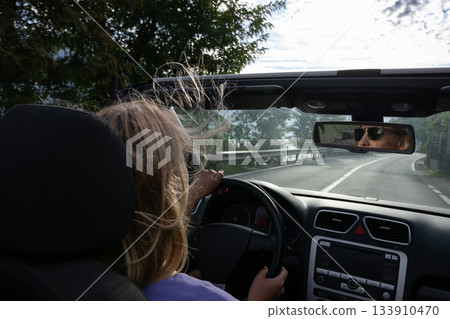 Young woman driving convertible along scenic ocean coast and mountain road at sunset, carefree summer vacation, travel freedom and adventure on coastal highway Young woman driving convertible along scenic ocean coast and mountain road at sunset, carefree summer vacation, travel freedom and adventure on coastal highway 133910470