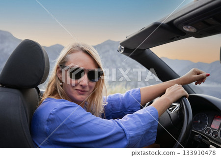 Young woman driving convertible along scenic ocean coast and mountain road at sunset, carefree summer vacation, travel freedom and adventure on coastal highway Young woman driving convertible along scenic ocean coast and mountain road at sunset, carefree summer vacation, travel freedom and adventure on coastal highway 133910478