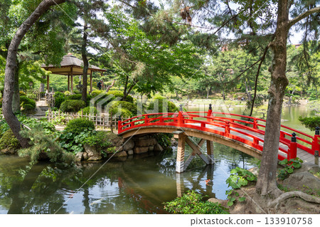 Red bridge in Shukkei-en Japanese garden in Hiroshima, Japan 133910758