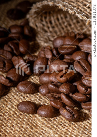 Rustic close-up of fresh coffee beans on a natural burlap background 133911378