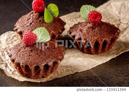 Mouth-watering muffins with raspberries on a chic black kitchen table surface Mouth-watering muffins with raspberries on a chic black kitchen table surface 133911394