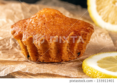 Golden lemon muffin with juicy lemon slices on a charming kitchen table Golden lemon muffin with juicy lemon slices on a charming kitchen table 133911401
