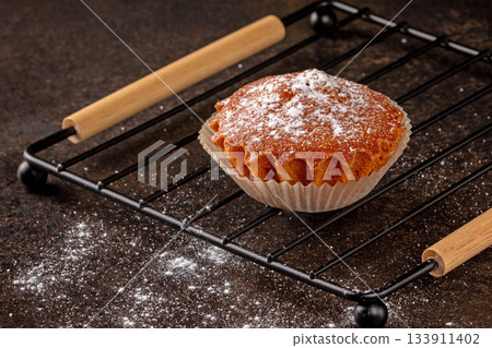 Freshly baked lemon muffin with a bright yellow hue on black background Freshly baked lemon muffin with a bright yellow hue on black background 133911402