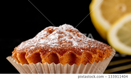 Fresh sliced lemon and a sprinkle of powdered sugar on black surface 133911404